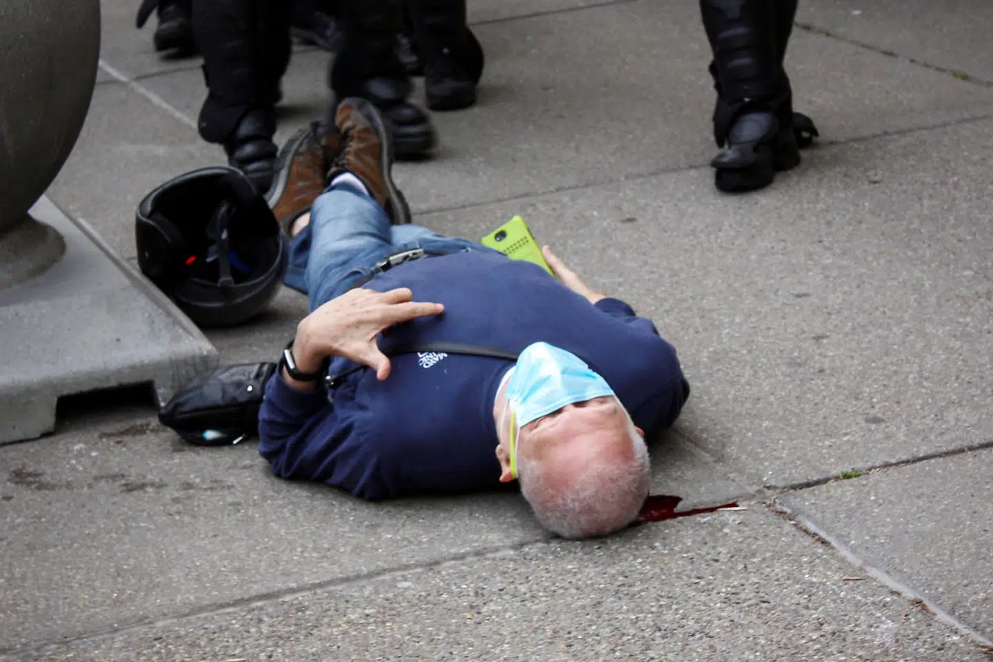 Her ligger den blødende demonstrant Martin Gugino (75) blødende på jorden i Buffalo, New York.