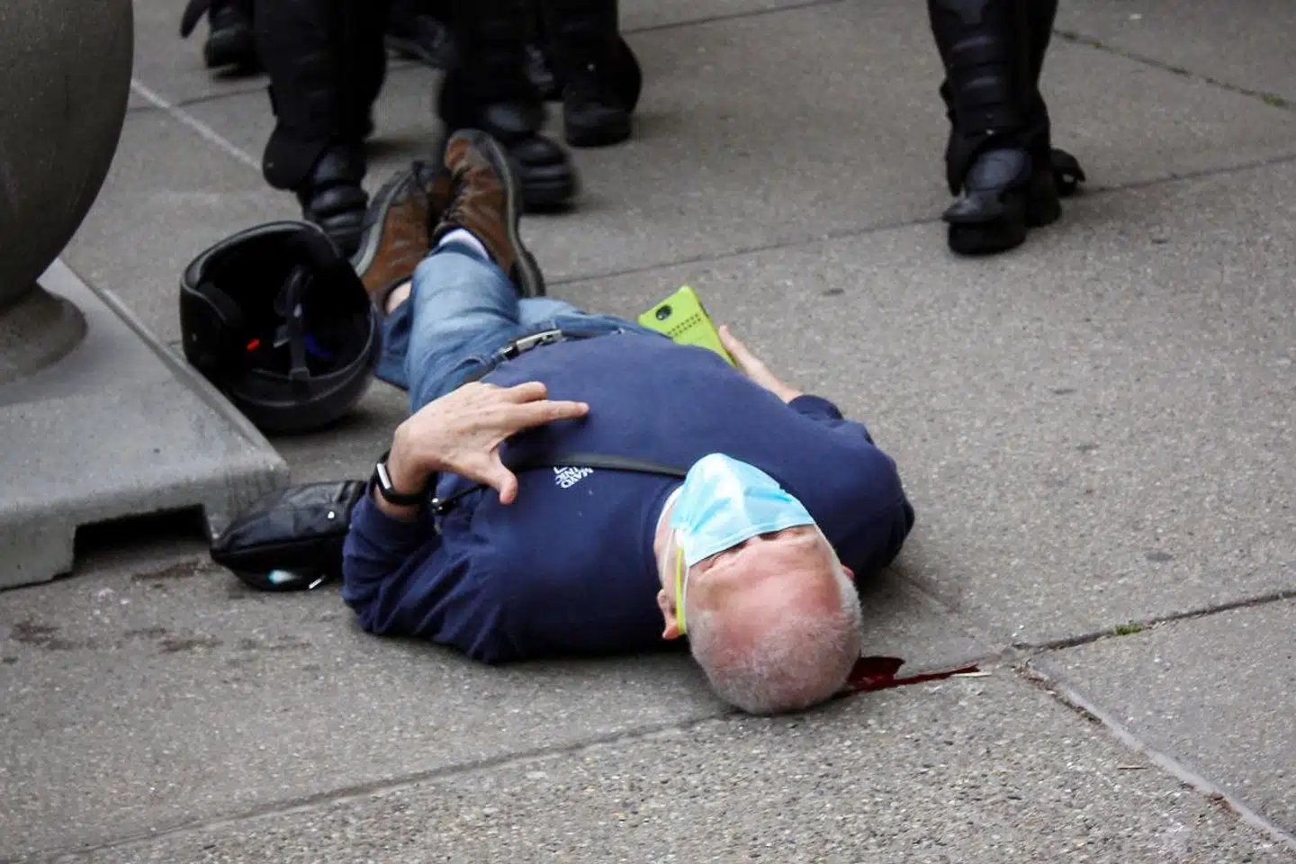 Her ligger den blødende demonstrant Martin Gugino (75) på jorden i Buffalo, New York.