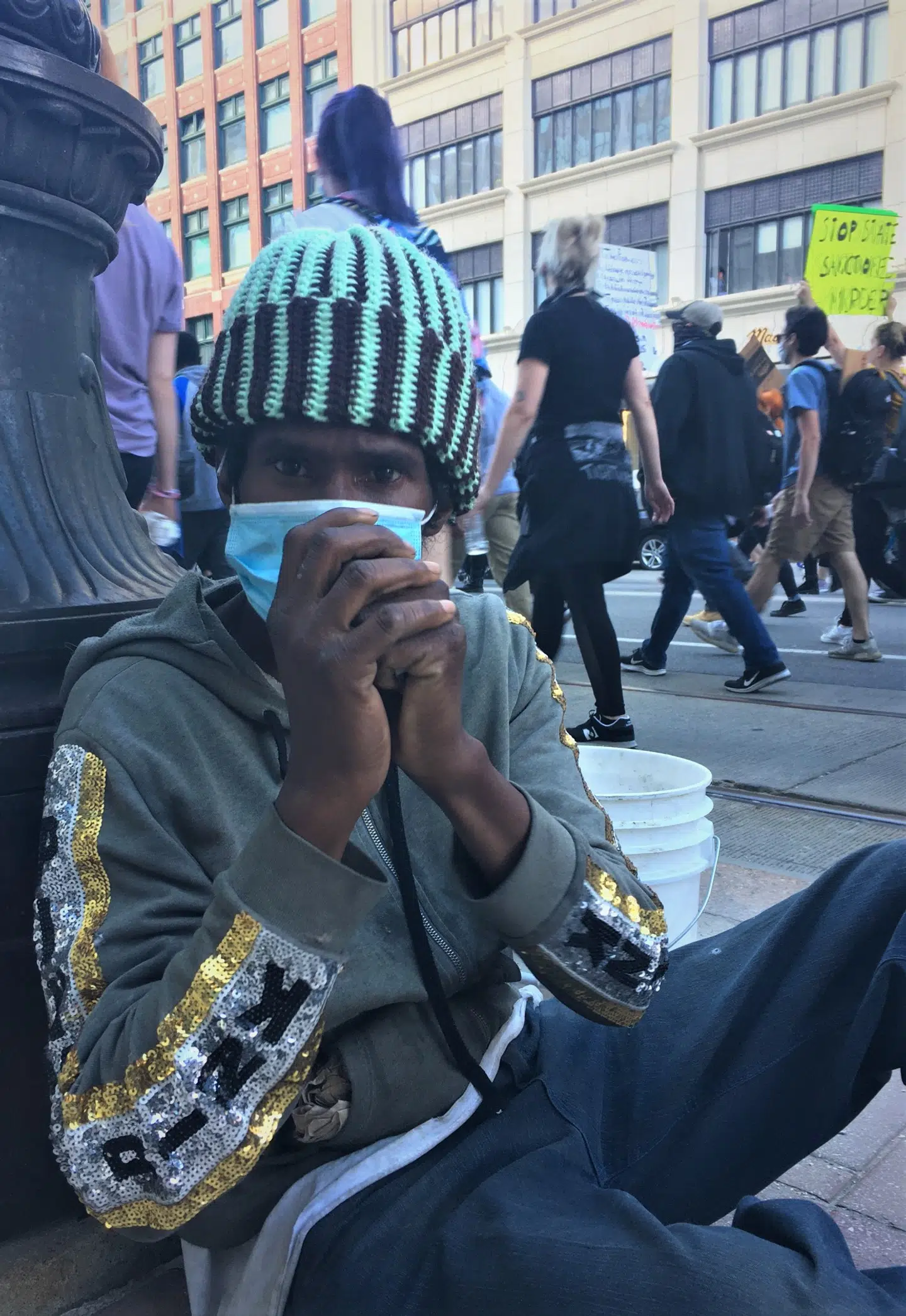 Den hjemløse detroiter Toby Senegal forsøger at vække demonstranternes opmærksomhed.