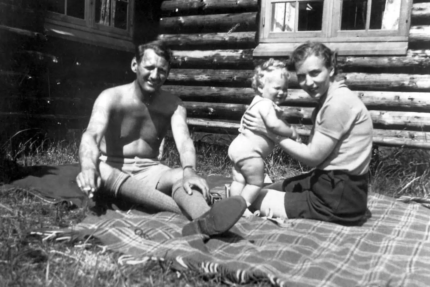 Kronprins Frederik lufter sine tatoveringer og kronprinsesse Ingrid hjælper lille Margrethe med at holde balancen, da kronprinsparret i 1941 holdt sommerferie i den kongelige jagthytte i Trend.