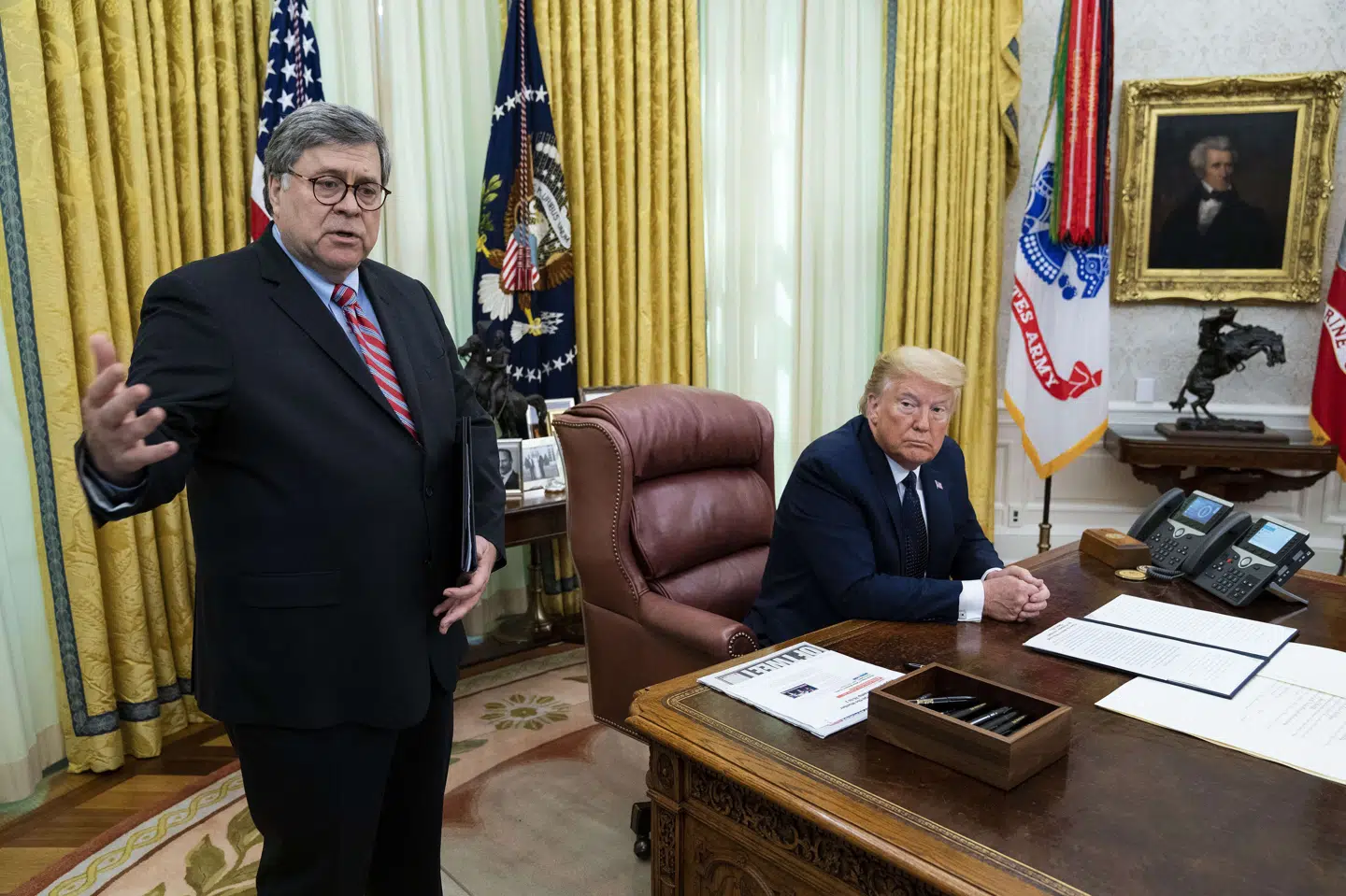 Justitsminister Barr, der står op, mener, at urostiftere krydser statsgrænser i USA for at lave uroligheder, og det er ikke lovligt. Præsident Trump, der sidder ved sit skrivebord, siger, at militæret måske skal sættes ind. Pool/Ritzau Scanpix