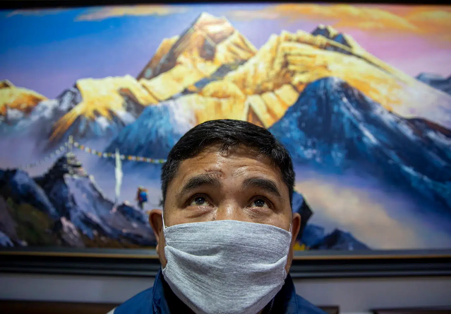 Der er adgang forbudt for almindelige bjergbestigere på Mount Everest på grund af coronapandemien. Har har en galleriejer i Kathmandu taget en ansigtsmaske på.