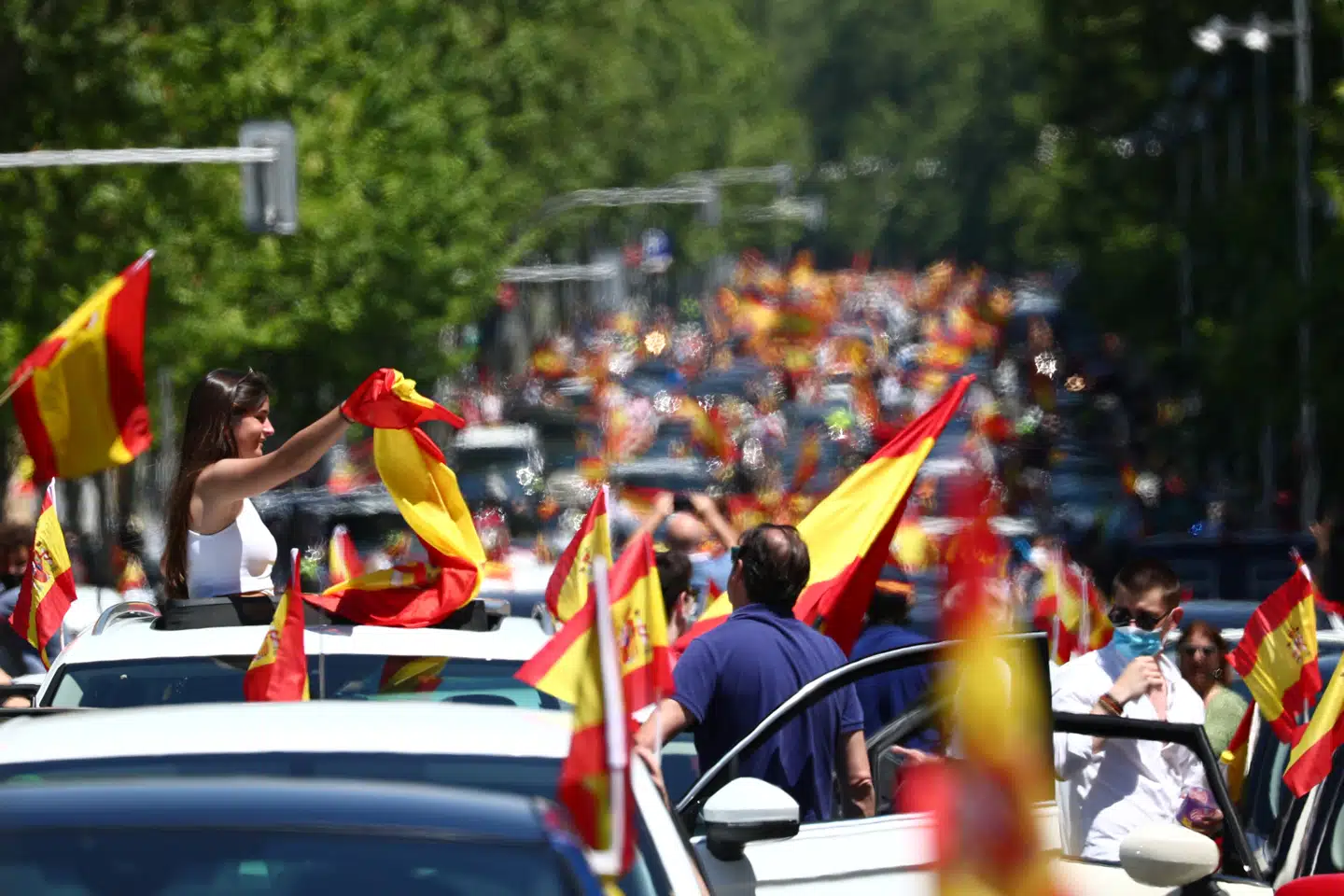 Demonstranter med spanske flag kørte lørdag gennem Madrids gader i en drive-in demonstration indkaldt af højrefløjspartiet Vox. Også i flere andre byer var der demonstrationer mod regeringens håndtering af coronakrisen og ikke mindst nedlukningen og de konsekvenser, den har for den spanske økonomi. Sergio Perez/Reuters
