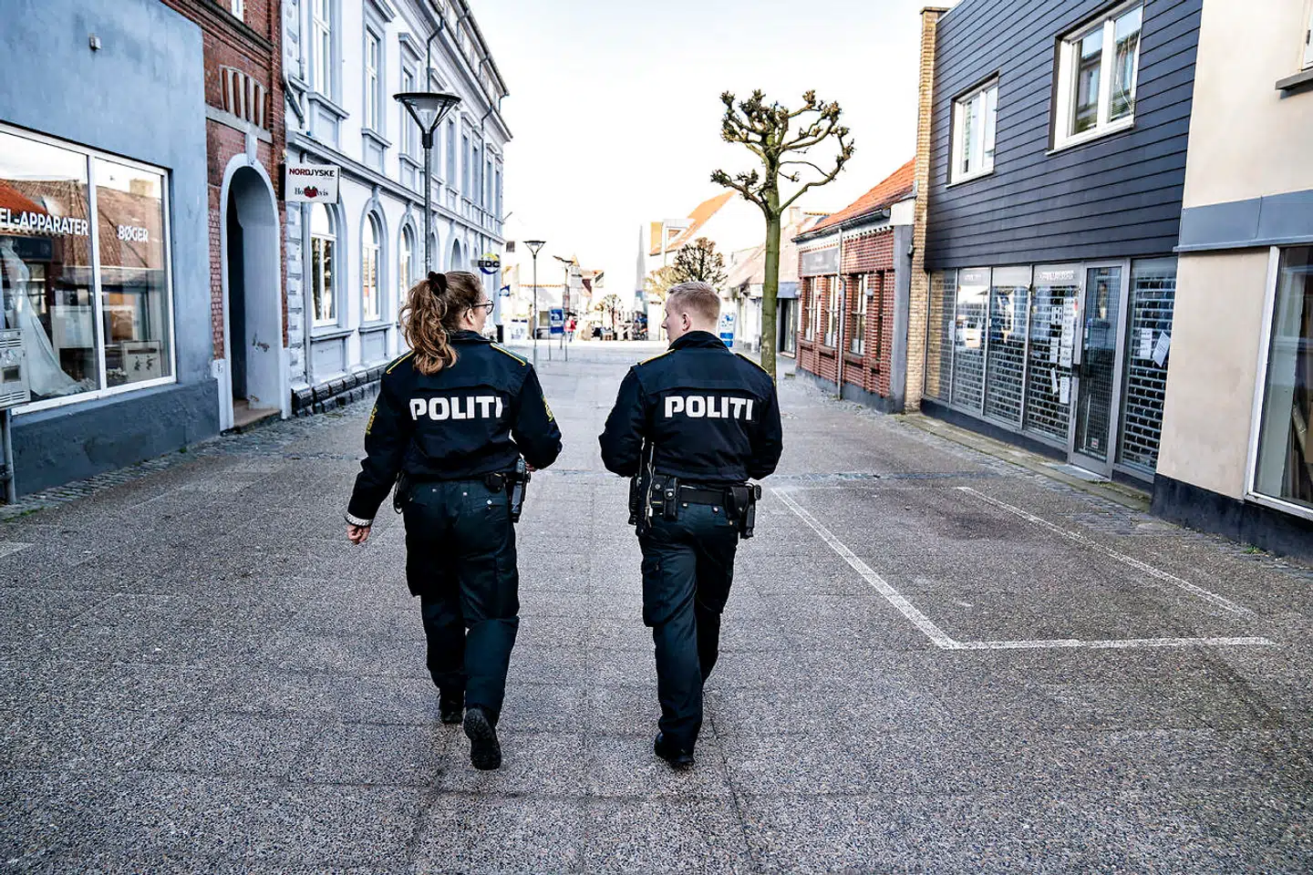 (ARKIVFOTO) Politi patruljerer i gågaden i Hobro, torsdag den 19. marts 2020. På turen i gågaden gik politiet ind i butikker for at sikre sig at der var de rigtige skilte med advarsler om corona i døren og håndsprit i butikken. Ritzau Scanpix.