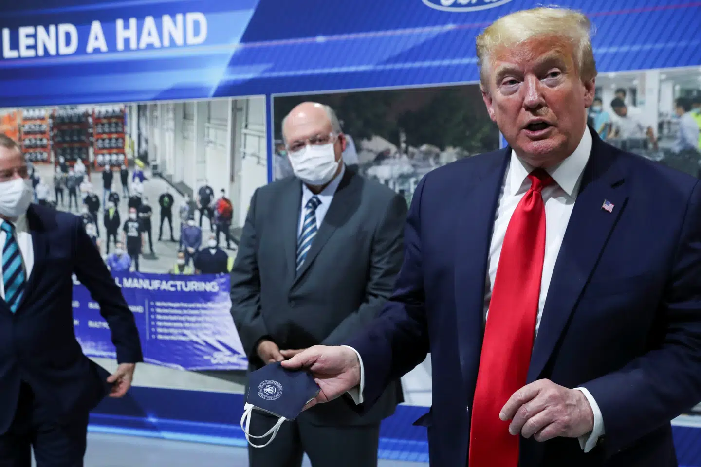 Omringet af maskebærende direktører fra Ford-selskabet på Ford-fabrikken sagde Donald Trump - uden maske - (til højre), at han havde brugt en maske før, da han ikke blev filmet og fotograferet. Leah Millis/Reuters