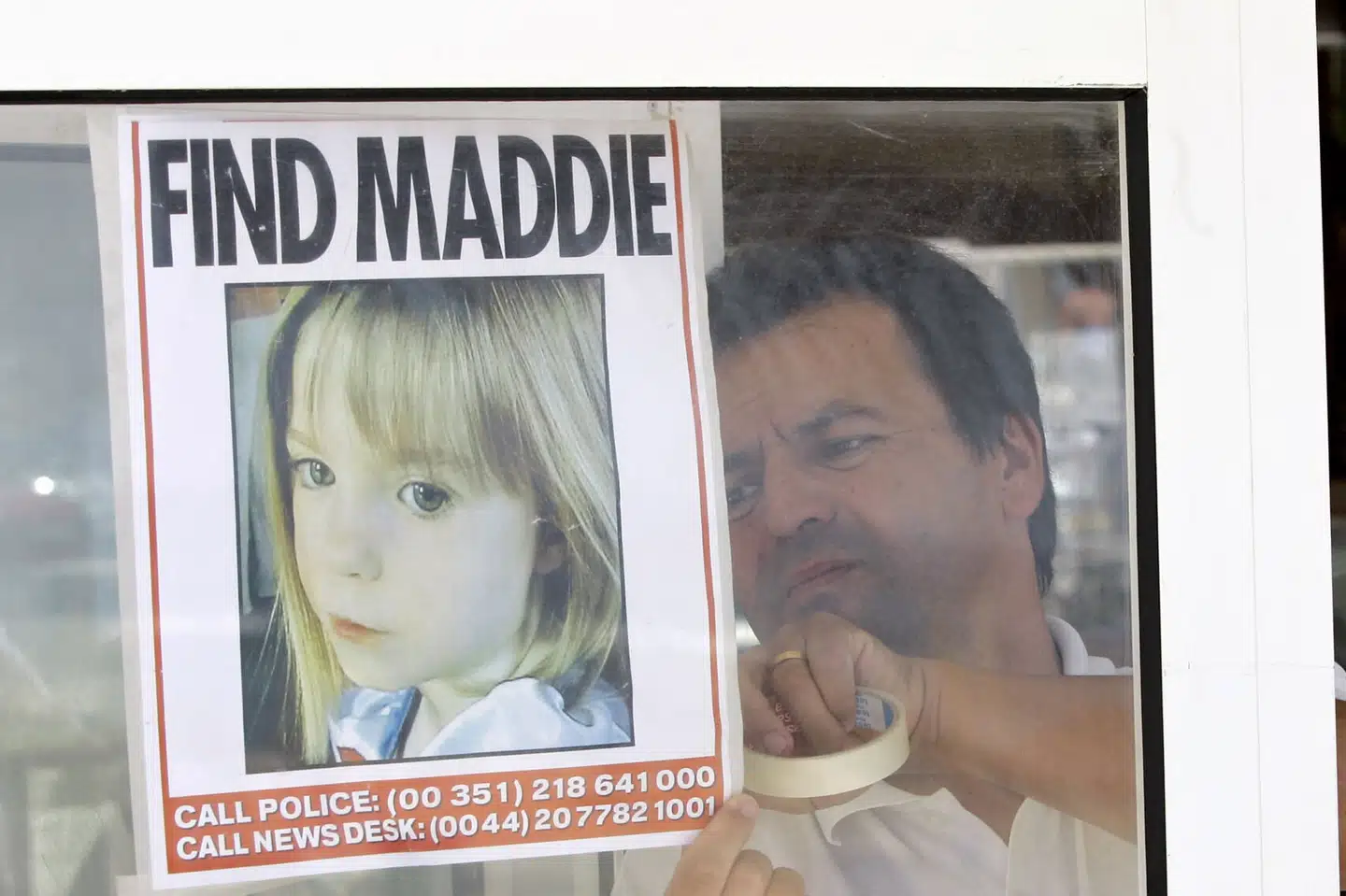 En tjener på en restaurant på Algarvekysten i Portugal hænger et billede op af den savnede Madeleine McCann. Den dengang treårige britiske pige forsvandt i 2007, mens hun var på ferie sammen med sine forældre i Praia da Luz. Nu starter en ny efterforskning ved en afsides sø i området (arkivfoto).