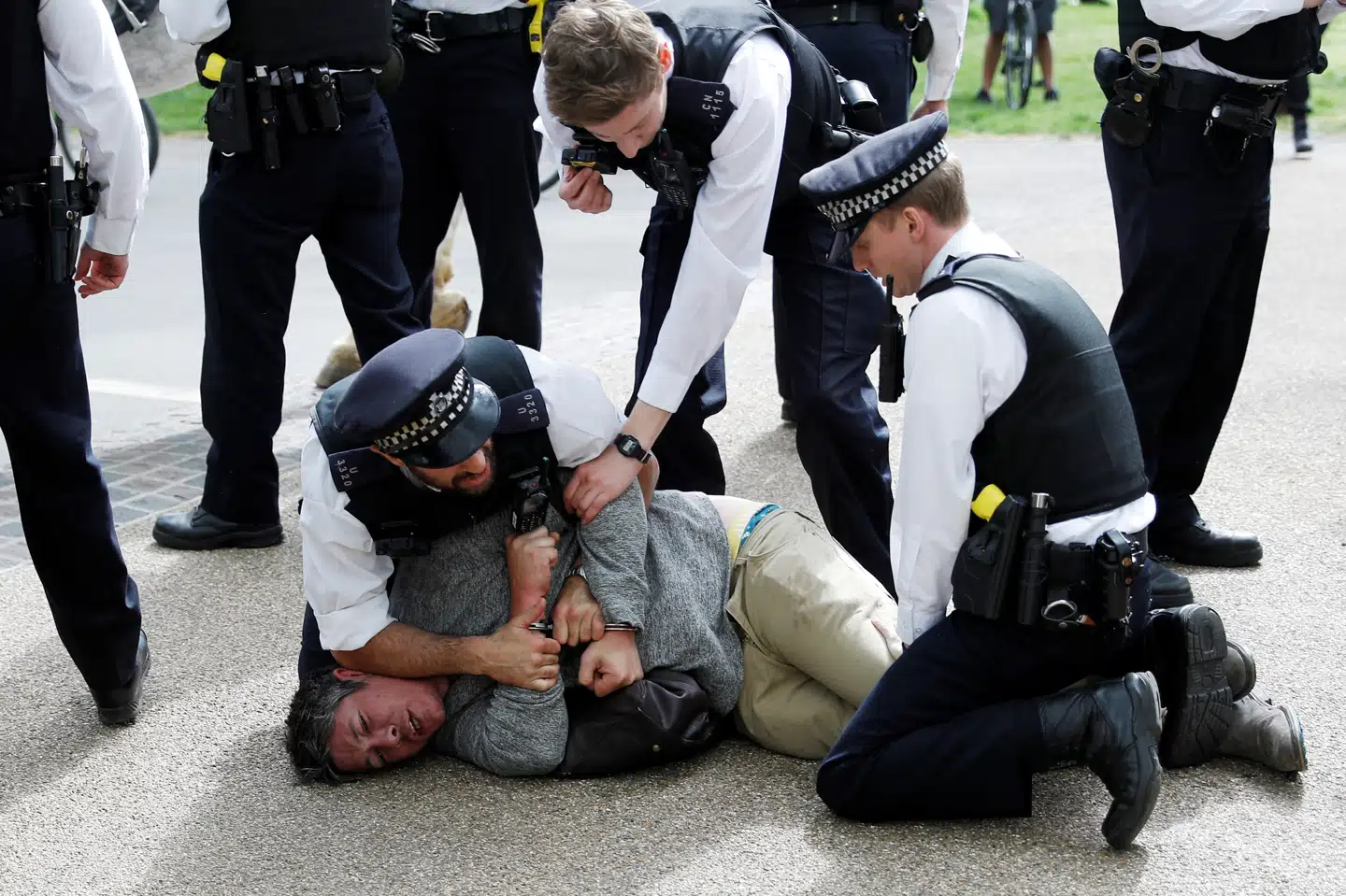Demonstant overmandet af politi i Hyde Park efter coronakrisens udbrud. Den britiske anklagemyndighed forbereder over 300 straffesager mod personer, som har spyttet eller hostet på politifolk og hospitalsansatte og derefter sagt, at de var syge med Covid-19. Peter Nicholls/Reuters