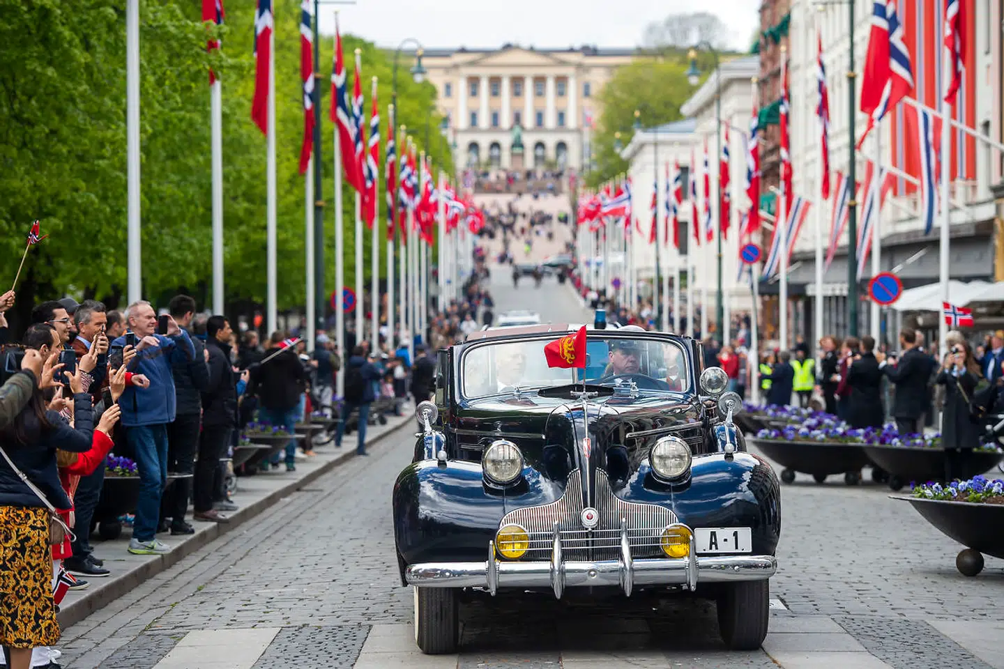 Kong Harald og dronning Sonja kørte ad Karl Johans gate i åben bil under fejringen på den norske nationaldag.