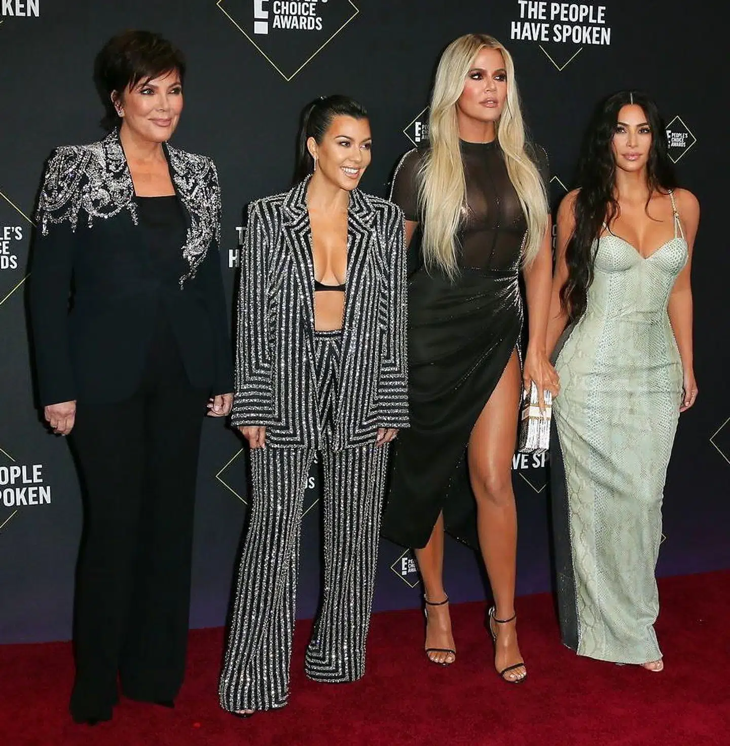 Kourtney Kardashian (i det stribede jakkesæt) med sin mor Kris Jenner og søstrene Khloé Kardashian og Kim Kardashian.