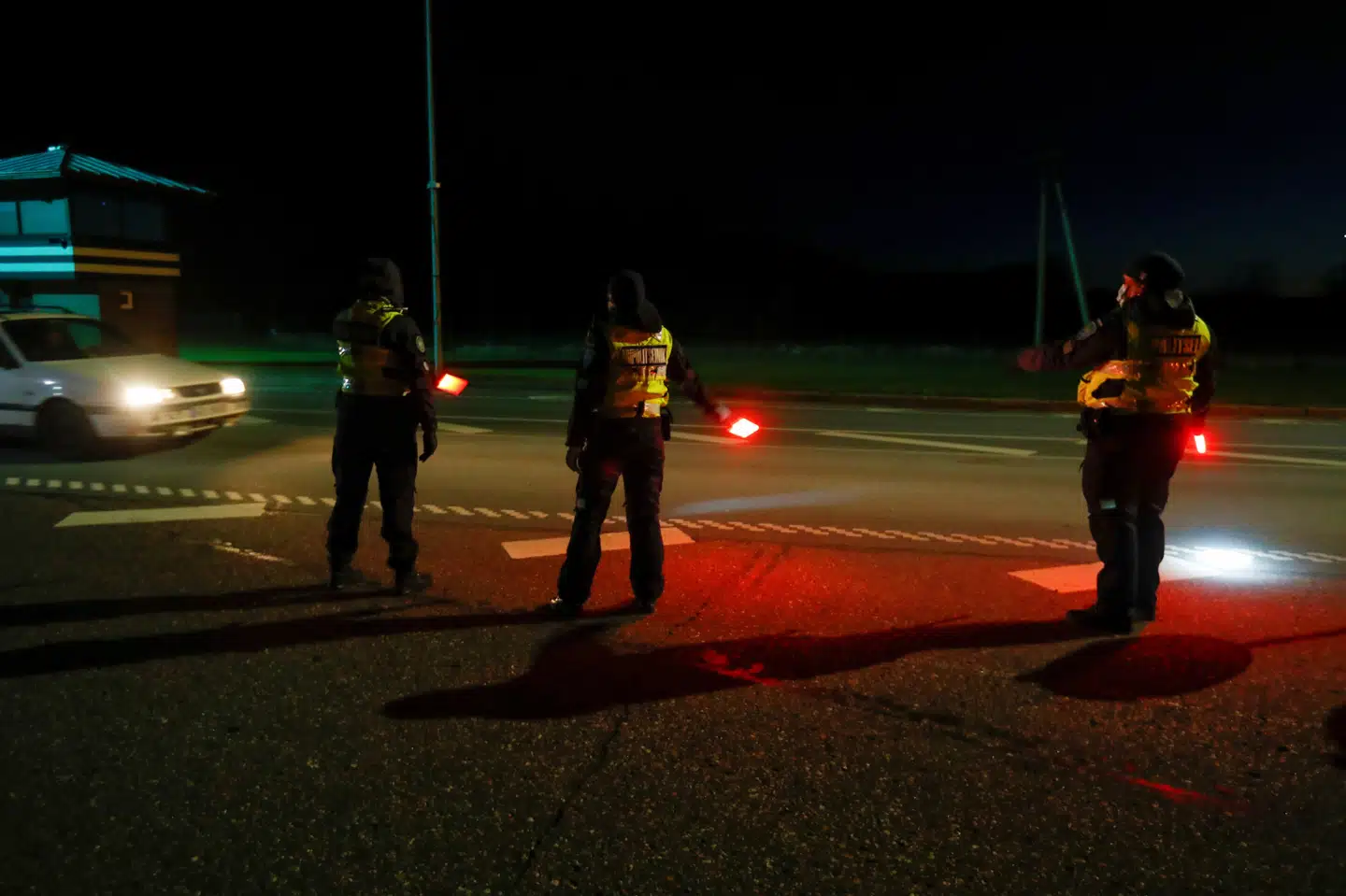 Estisk politi guidede borgere over grænsen til Letland ved midnatstid, da grænserne åbnede. Ints Kalnins/Reuters