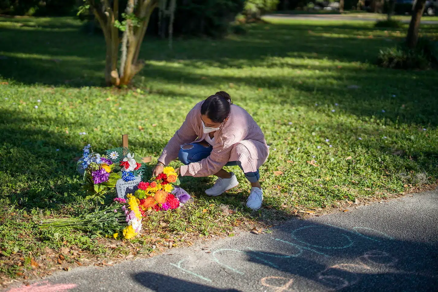 En beboer, Darling Rubin retter på blomster, der nu er lagt på gerningsstedet.