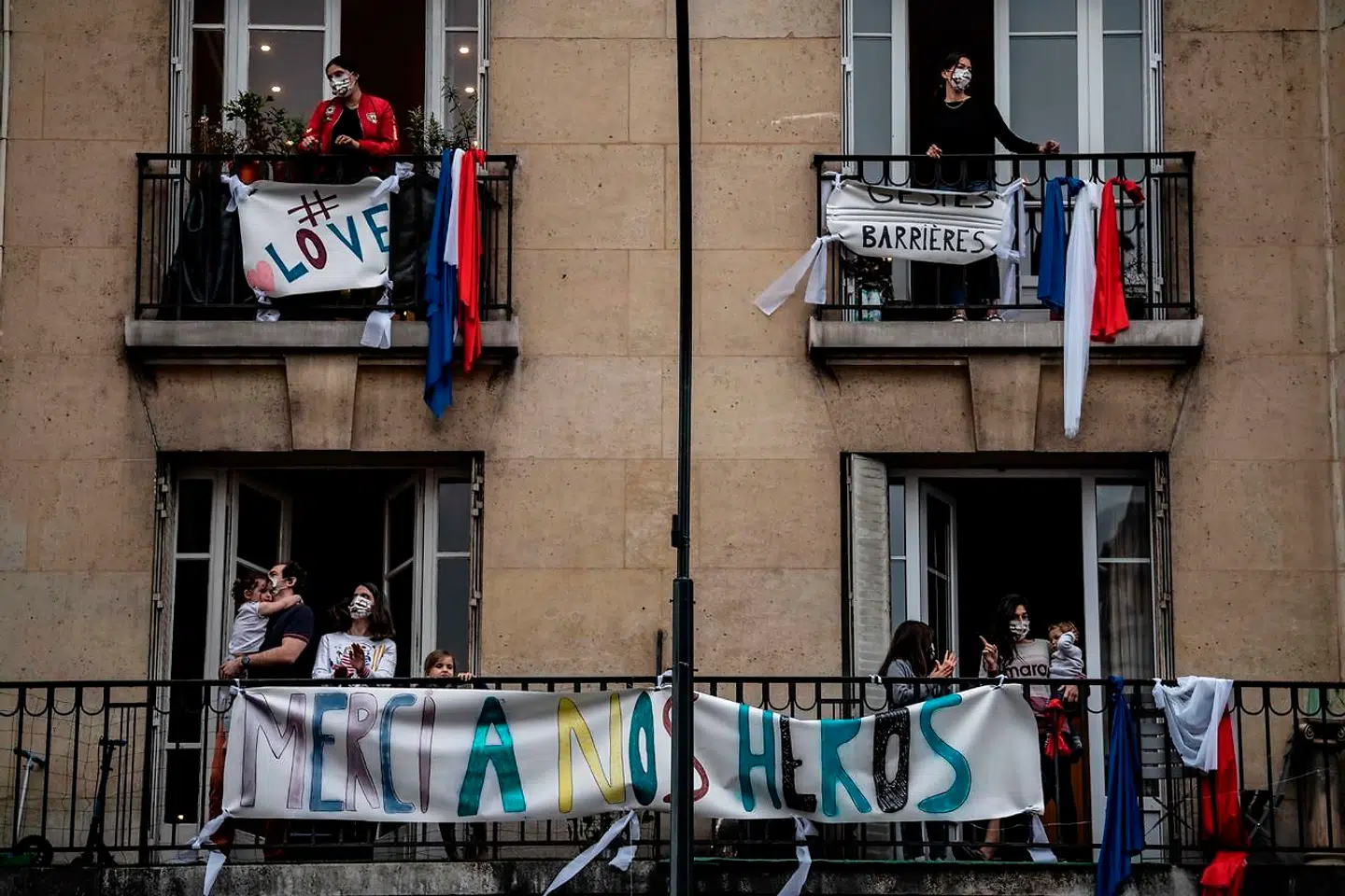 TOPSHOT - Inhabitants applaud at 20:00 along with others across the French nation, to show their support to healthcare employees in Saint-Mande, a Paris' suburb, on May 4, 2020 during the 49th day of a lockdown in France aimed at curbing the spread of the COVID-19 disease, caused by the novel coronavirus. (Photo by Martin BUREAU / AFP)