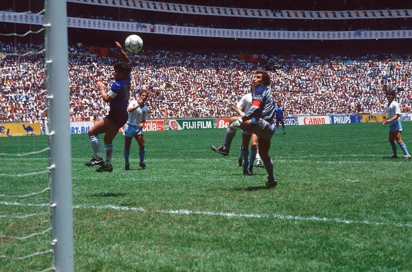 Maradona (tv.) scorer det berømte mål med hånden.
