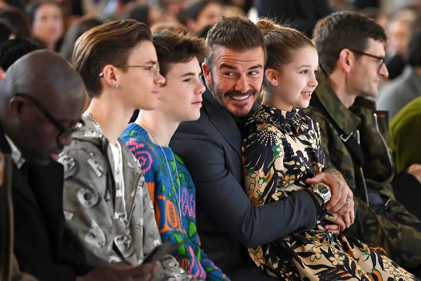 David Beckham med tre af parrets fire børn ved en af Victoria Beckhams modeopvisninger.