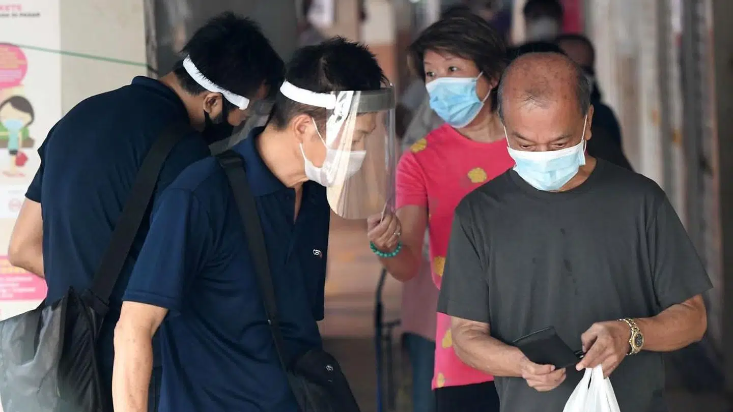 Folk viser deres identifikationskort for at få lov at komme på et madmarked