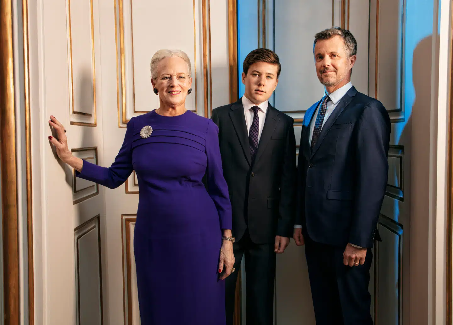 Dronningen, Kronprinsen og prins Christian står her i døråbningen til Røde Salon i Christian IX’s Palæ.