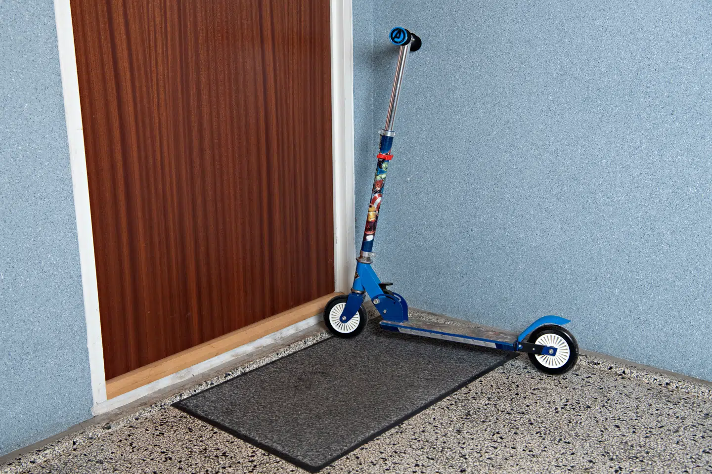 Karls løbehjul står i opgangen foran døren ind til familiens lejlighed.