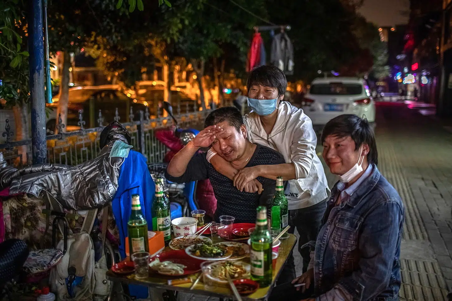 epa08351095 Men eat and drink in the street after the lockdown was lifted, in Wuhan, China, 08 April 2020. Wuhan, the epicenter of the coronavirus outbreak, lifted the lockdown on 08 April 2020, allowing people to leave the city after more than two months. According to Chinese government figures, over 2, 500 people have died of Covid-19 in Wuhan since the outbreak began. EPA/ROMAN PILIPEY