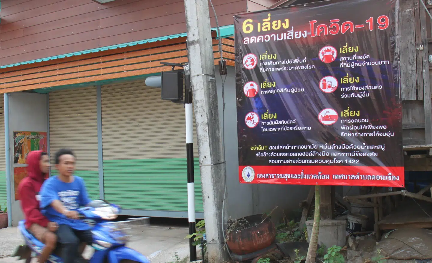 Et skilt med gode råd om covid-19 virussen på en hovedgade i landsbyen Don Khueang i Sakon Nakhon.