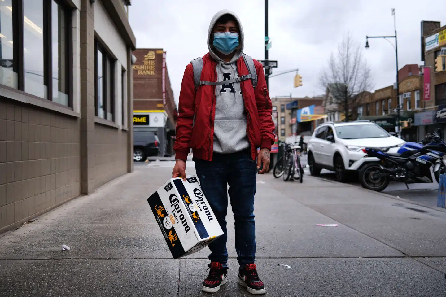En mand kommer gående med en kasse Corona-øl i Borough Park i Brooklyn, New York - en bydel, der har oplevet en kraftig stigning i antallet af coronapatienter på det seneste. New Yorks hospitaler mangler sengepladser, respiratorer og beskyttelsesudstyr til sundhedspersonalet. Spencer Platt/Ritzau Scanpix