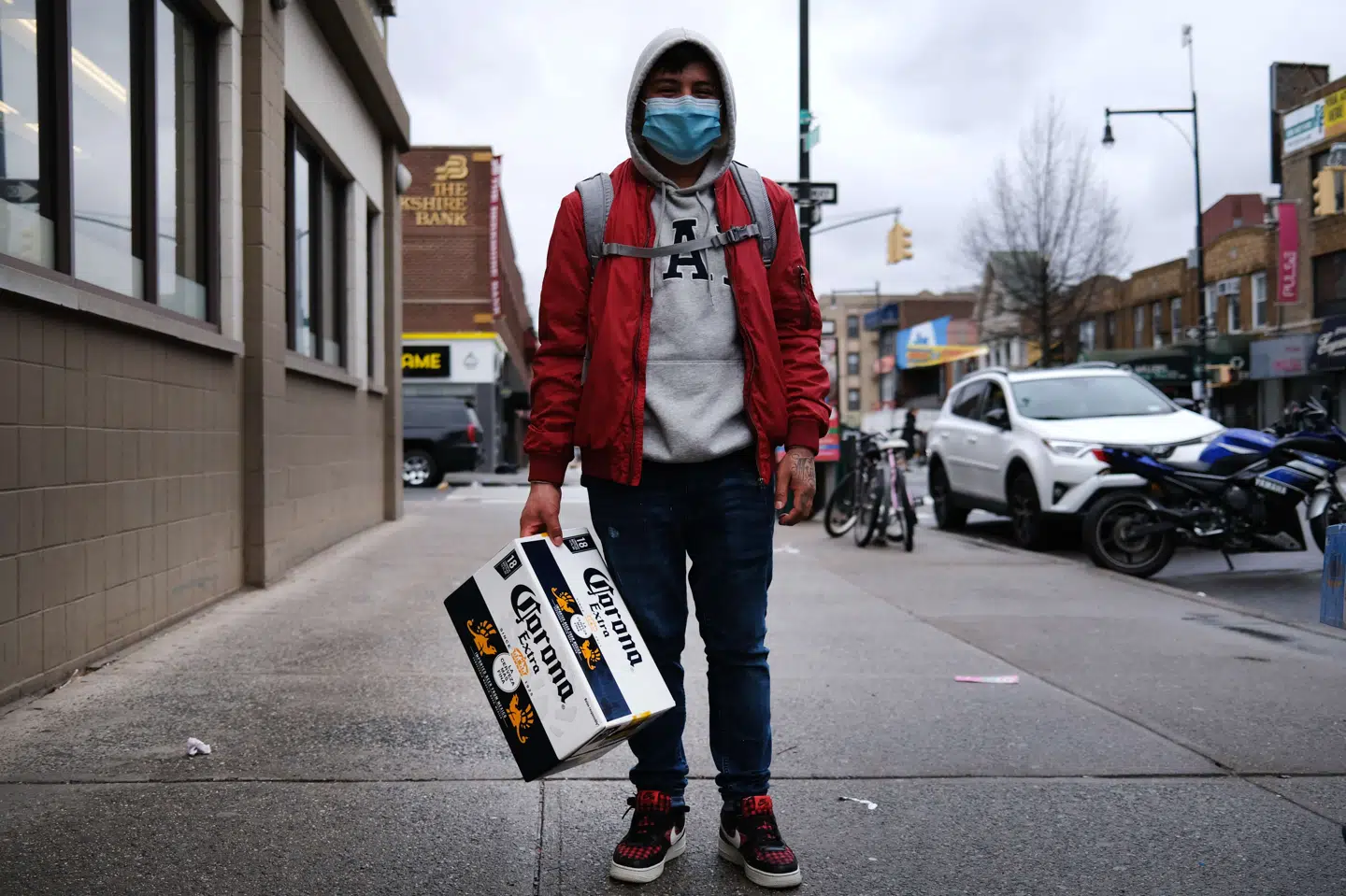 En mand kommer gående med en kasse Corona-øl i Borough Park i Brooklyn, New York - en bydel, der har oplevet en kraftig stigning i antallet af coronapatienter på det seneste. New Yorks hospitaler mangler sengepladser, respiratorer og beskyttelsesudstyr til sundhedspersonalet. Spencer Platt/Ritzau Scanpix