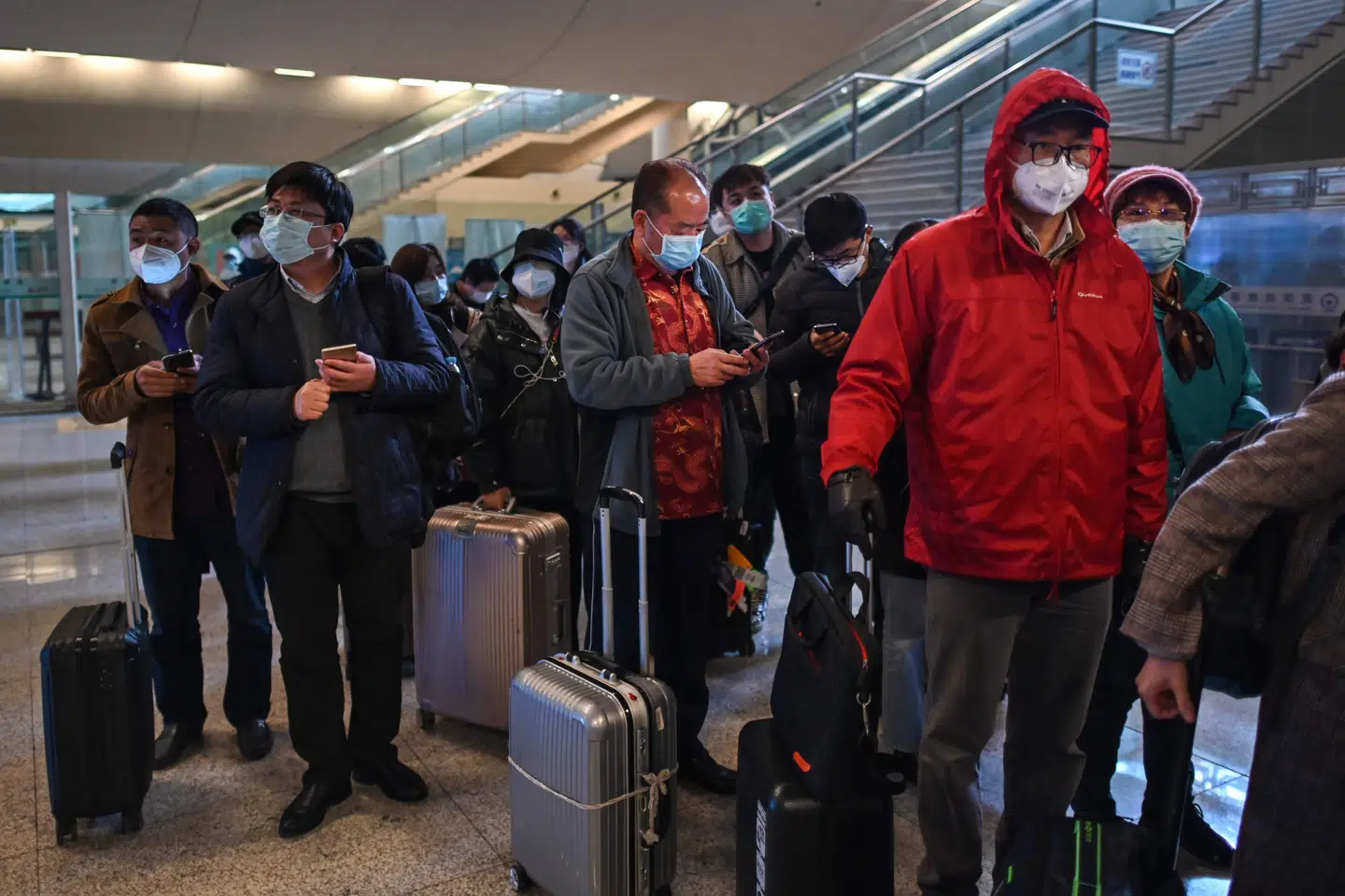 Med masker for ansigtet venter passagerer i kø efter ankomsten til togstationen i Wuhan lørdag. Den to måneder lange totale nedlukning, som myndighederne i byen indførte på grund af coronaudbruddet, er gradvist blevet lempet i denne uge. Hector Retamal/Ritzau Scanpix