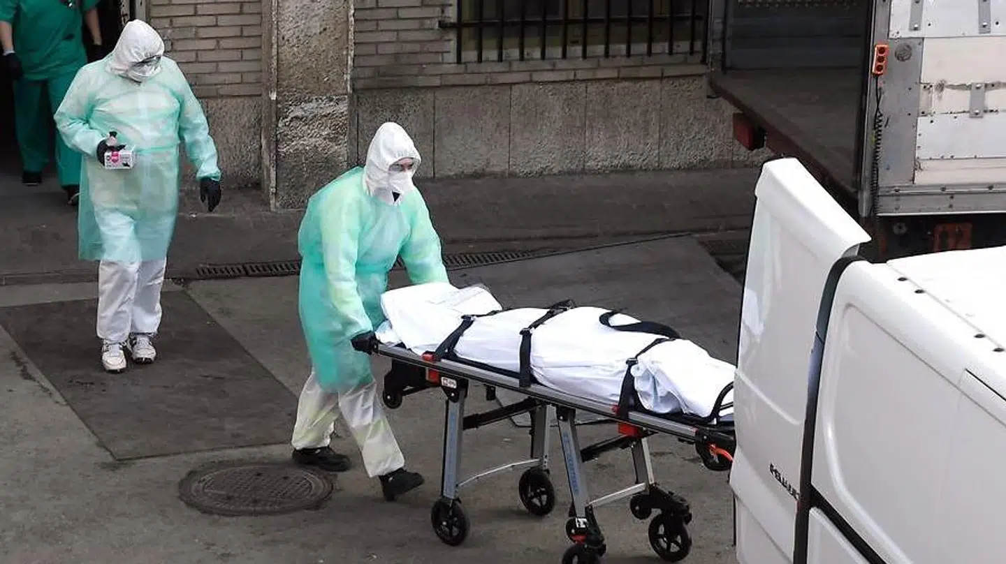 En sundhedsarbejder kører en afdød patient væk fra et hospital i Madrid. Spanien har nu registreret flere corona-relaterede dødsfald end Kina.