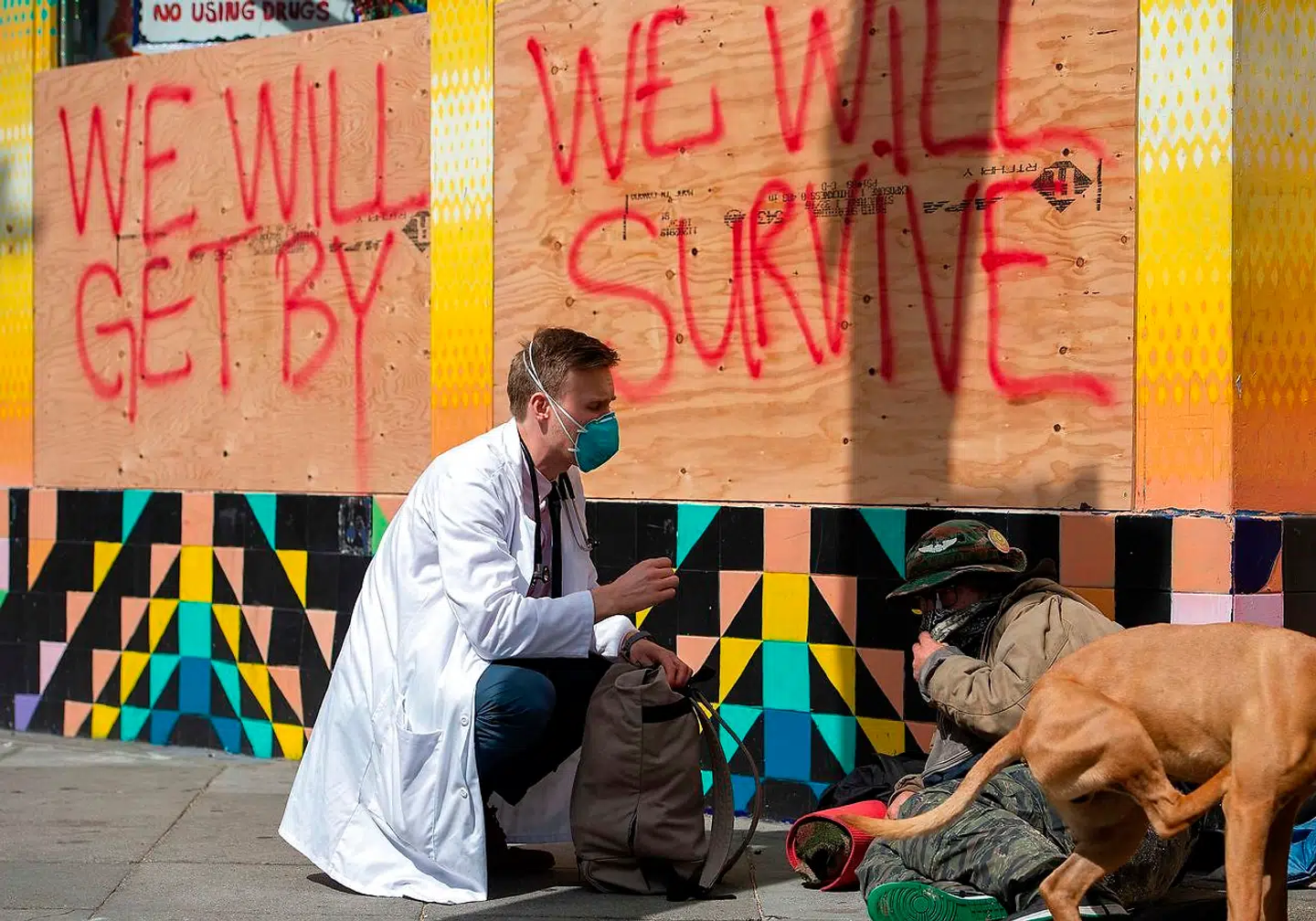 Stuart Malcolm, en læge ved Haight Ashburdy Free Clinic, taler med hjemløse om coronavirussen. AFP.
