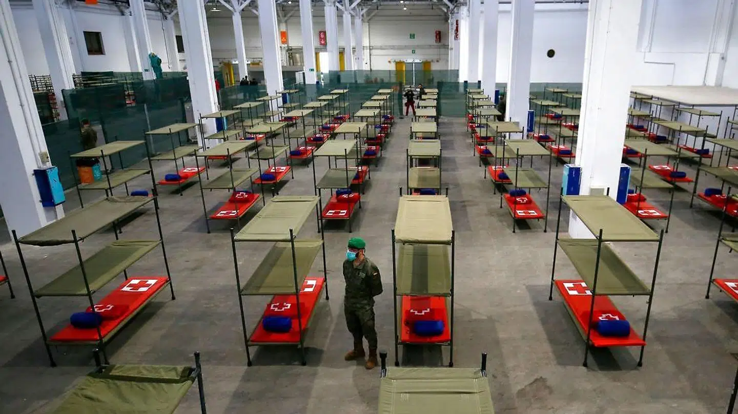 En soldat står ved en af de mange senge på et midlertidigt hospital for sårbare borgere i Barcelona.