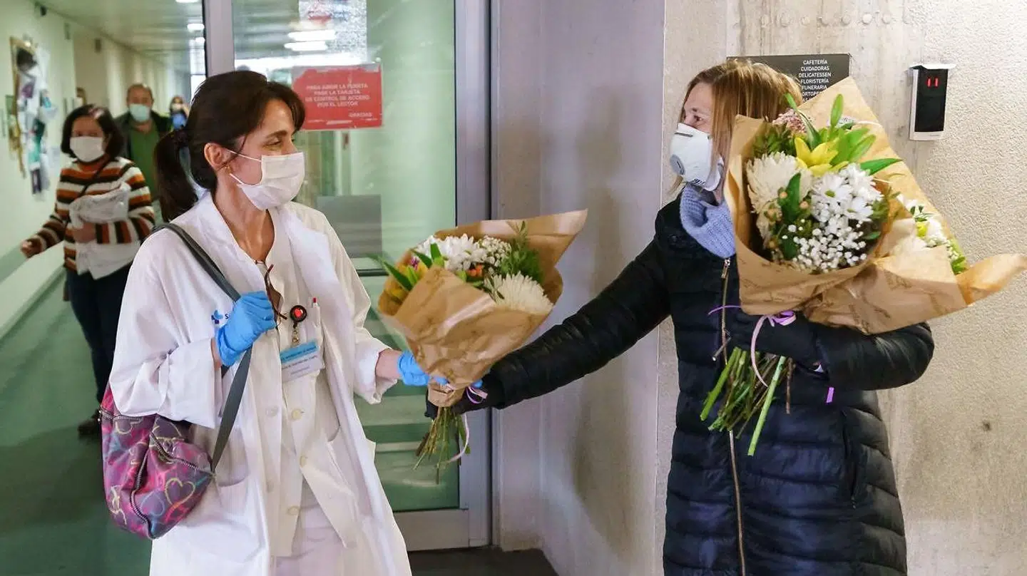 En blomsterhandler giver blomster til sundhedsmedarbejdere foran et hospital i den nordspanske by Burgos. Mere end 5.400 spanske sundhedsmedarbejdere er testet positive for coronavirus.