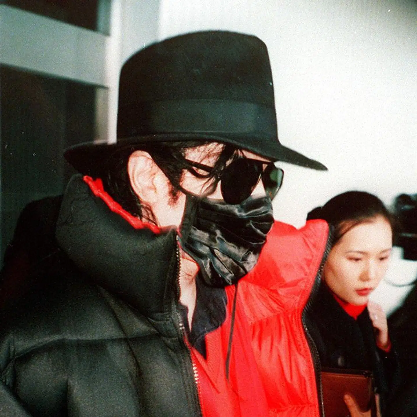 Michael Jackson er her fotograderet i lufthavnen i Seoul i 1997 - iført sort mundbind.