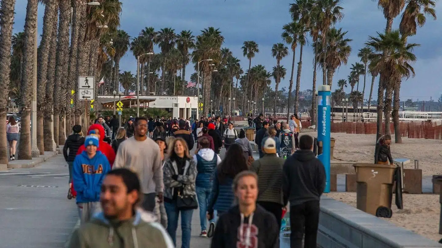 Folk går ture - uden at holde afstand - ved Santa Monica Beach i Californien natten til fredag dansk tid.