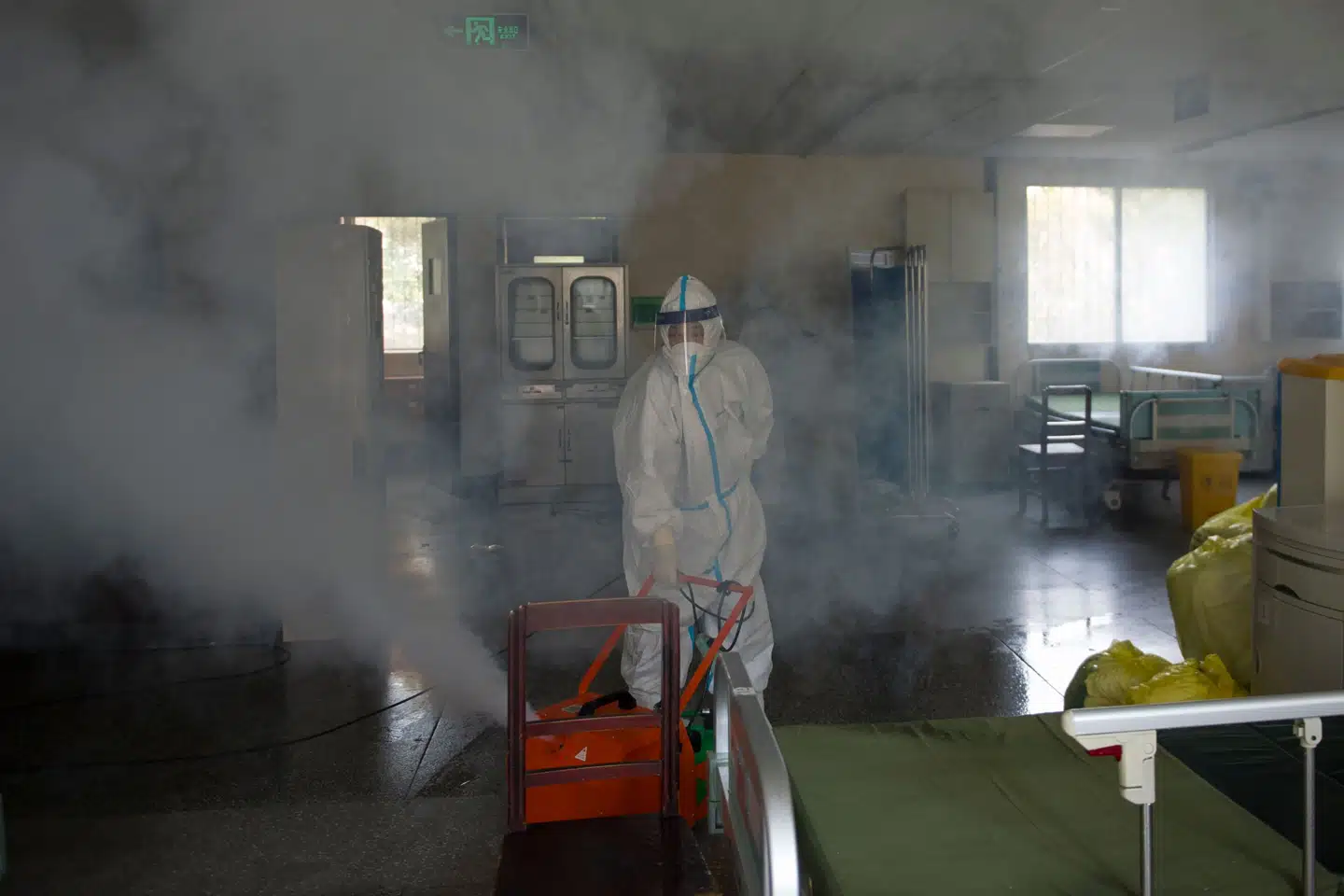 En medarbejder desinficerer en hospitalsstue i den kinesiske by Wuhan. Det var, virusset brød ud i december. Str/Ritzau Scanpix