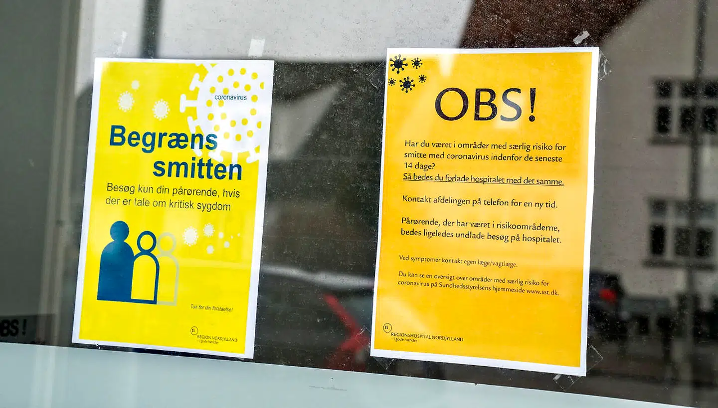 Gule advarselsskilte om smittebegrænsning og kun nødvendige besøg af pårørende ved indgangenene til Regionshospital Nordjylland i Hjørring. (Arkivfoto)