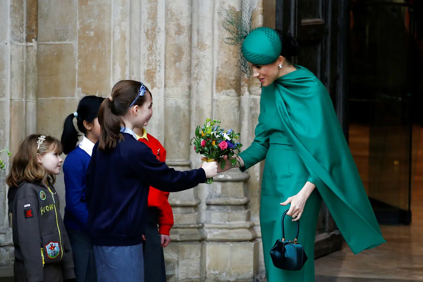 Hertuginde Meghan havde en grøn kjole på og tog imod en buket fra en lille pige.