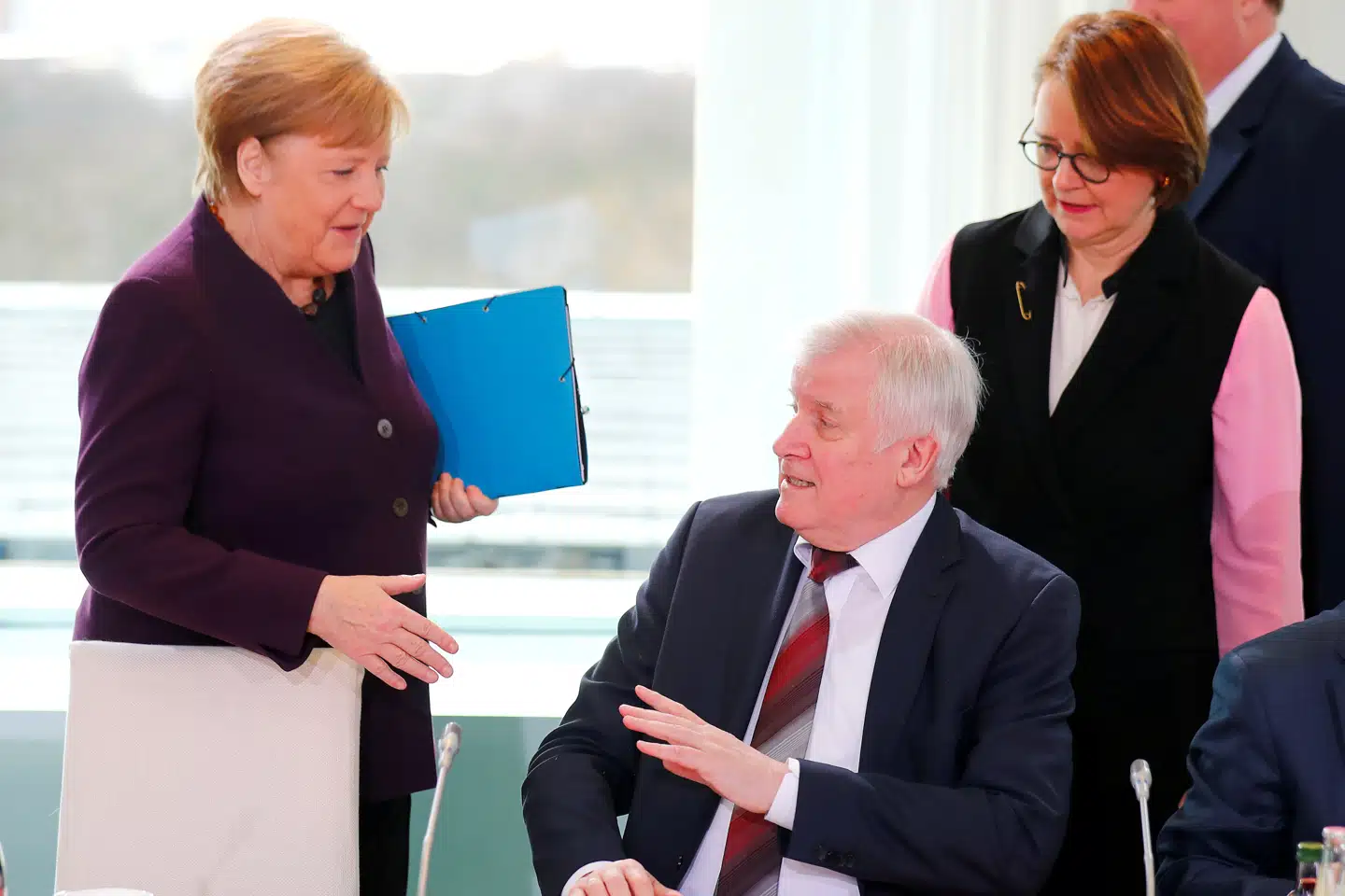 Tysklands indenrigsminister irettesatte venligt forbundskansler Angela Merkel, da hun mandag ville udveksle et håndtryk med ham. Hannibal Hanschke/Reuters