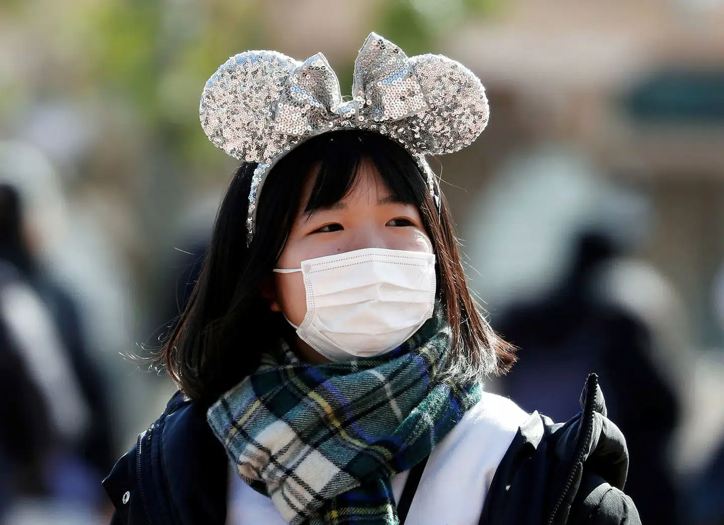 En besøgende bærer ansigtsmaske i Tokyo Disneyland.