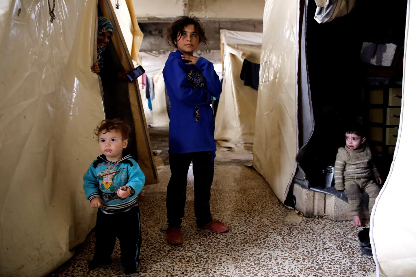 Børn af internt fordrevne syrere foran deres telt i en flygtningelejr i den syriske provins Idlib. Umit Bektas/Reuters