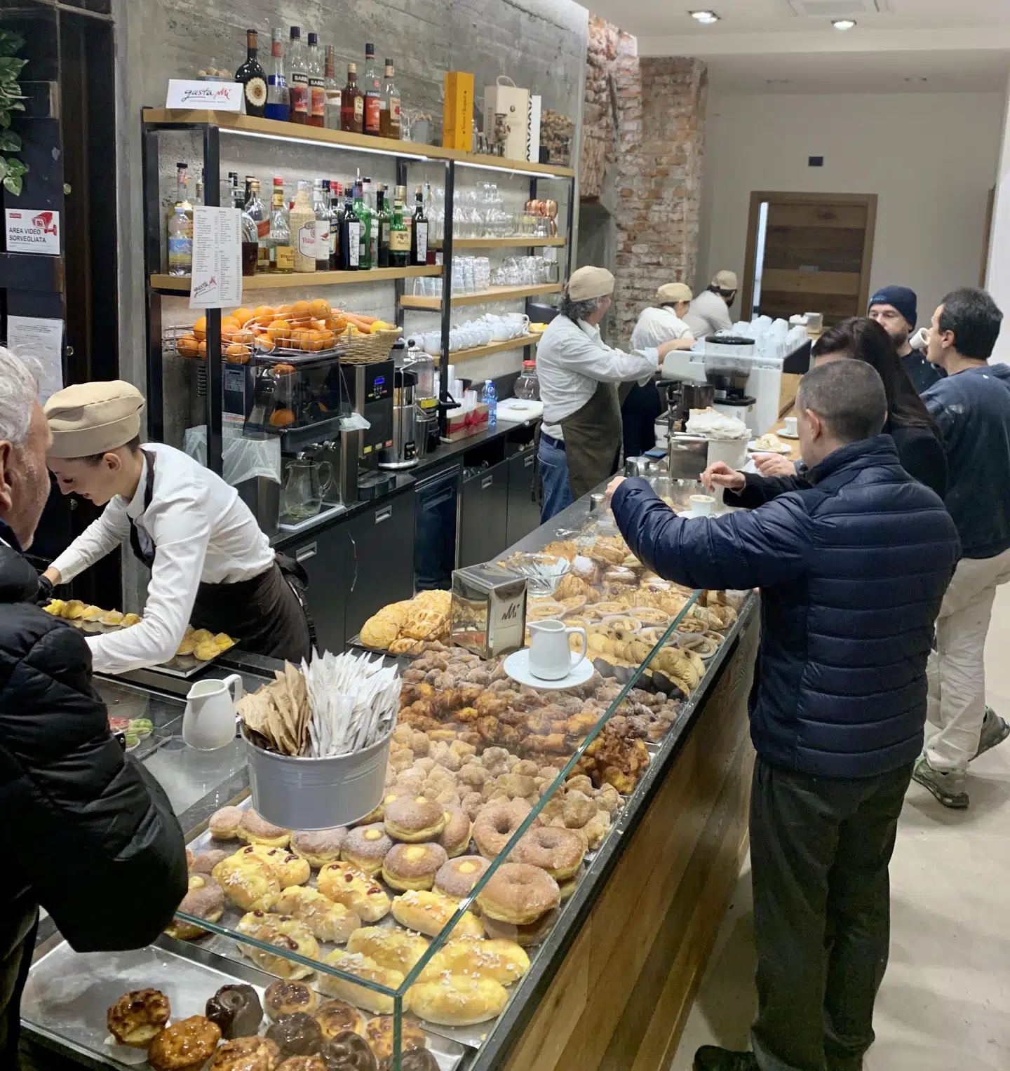 På et kvarter har de første 30 personer været forbi til en stående espresso og conetti på en cafe i Milano.
