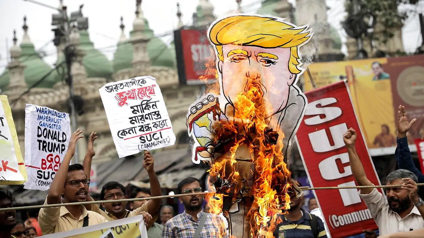 Et karikaturbillede af Donald Trump går op i flammer i forbindelse med en demonstration i storbyen Kolkata.