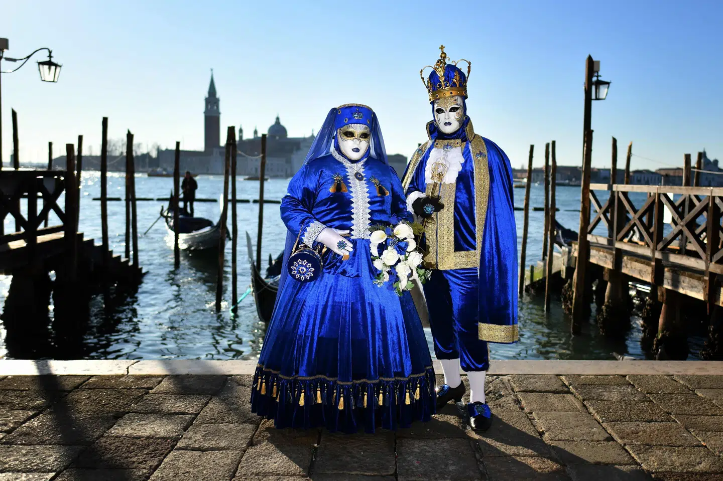 Folk i kostumer ses her tidligere i løbet karnevalet i norditalienske Venedig. Karnevalens sidste to dage er blevet aflyst på grund af et udbrud af coronavirus. Alberto Pizzoli/Ritzau Scanpix