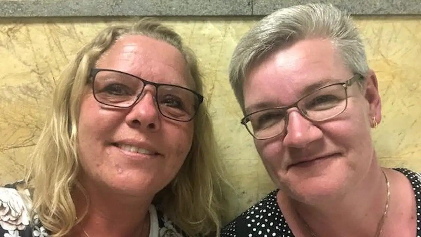 Tina Carlsen (tv) og hendes veninde Betinna, der sidder på gulvet i lufthavnen.