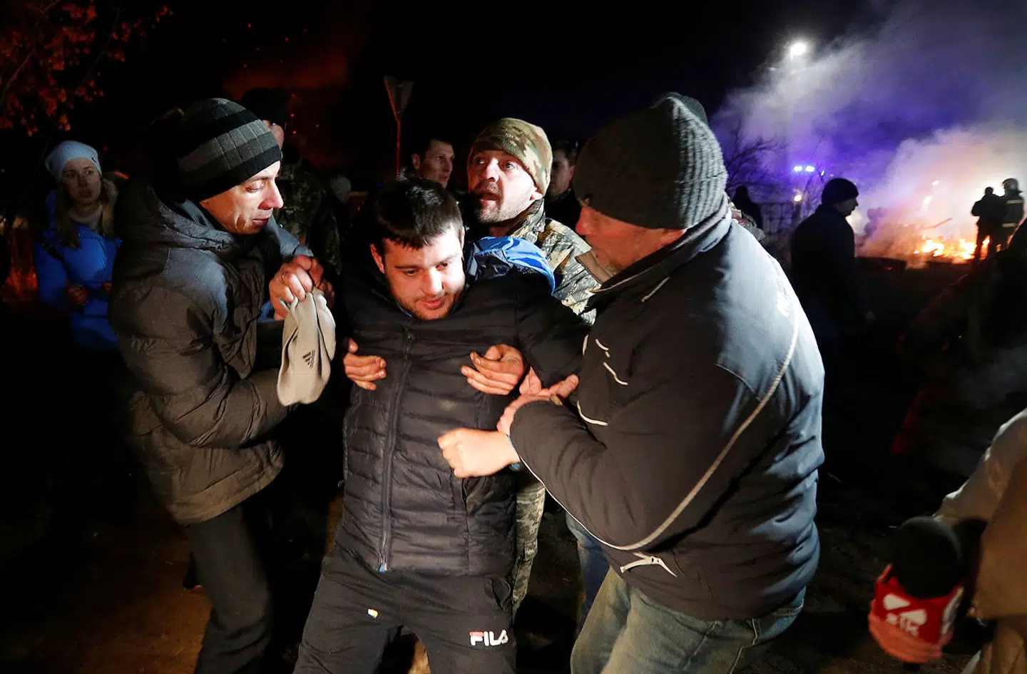 En såret mand får assistance af nogle protesterende i Ukraine.