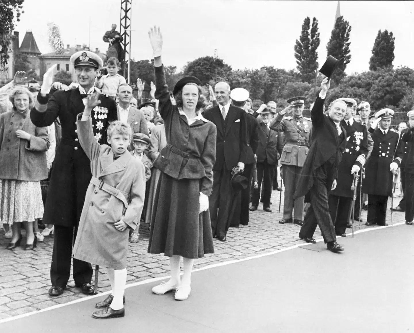 Arveprins Knud med datteren Elisabeth og sønnen Ingolf vinker farvel til kongeparret Frederik IX og dronning Ingrid, der rejser til Færøerne. Th. statsminister Hans Hedtoft, der i dagens anledning er i jaket og høj hat.