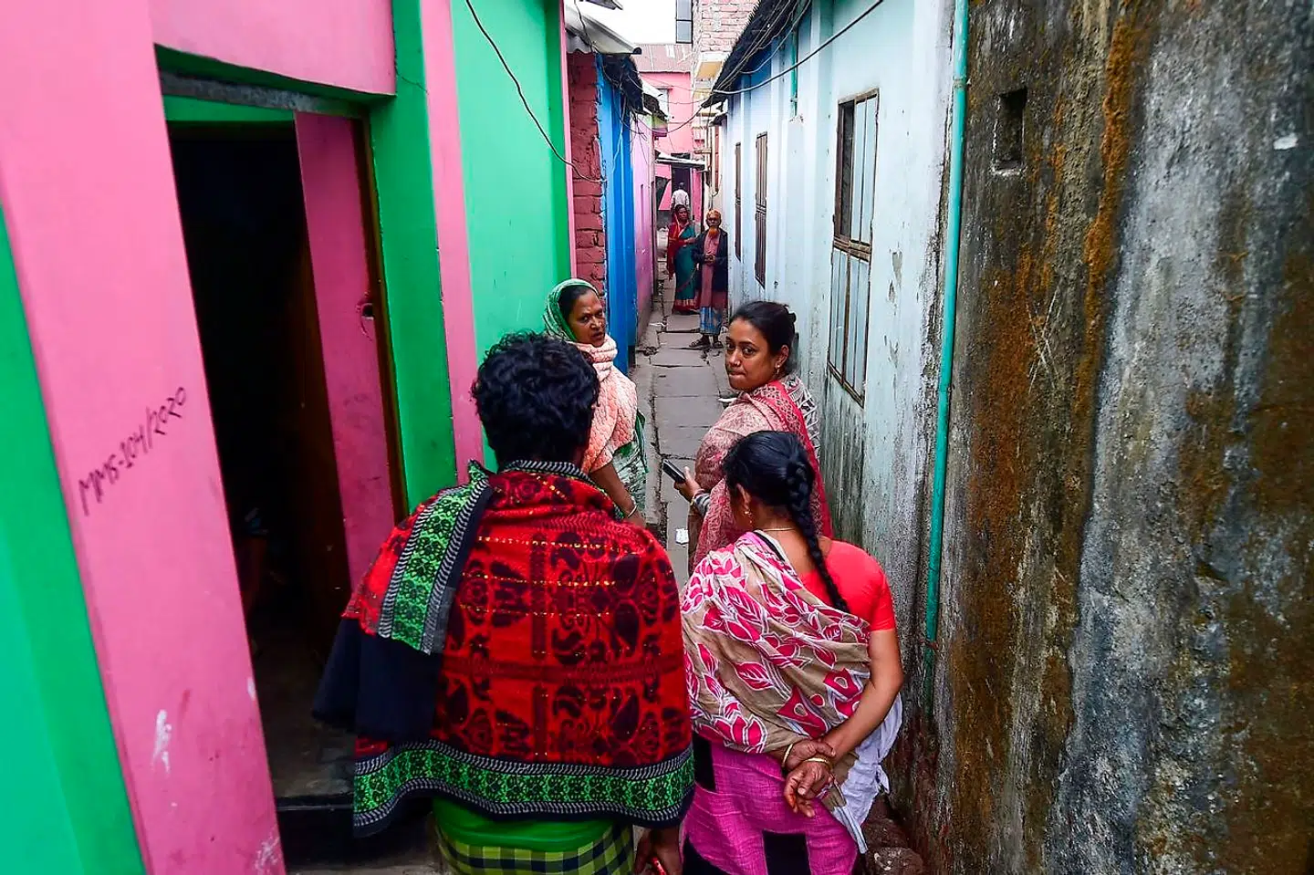 Her ses Jhumur Begum (til højre), som leder en gruppe af sexarbejdere, gå gennem bordellet Daulatdia.