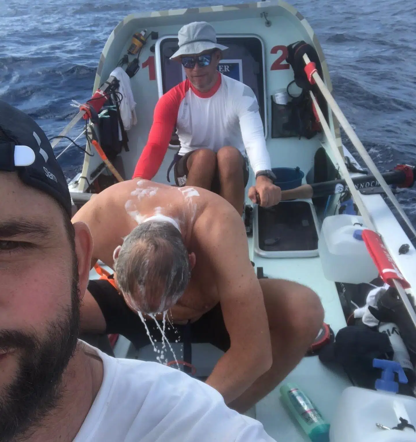 Mikkel har fanget et billede af Michael, der vasker hår. Den blå spand ved Anders' venstre hånd var mændenes toilet.