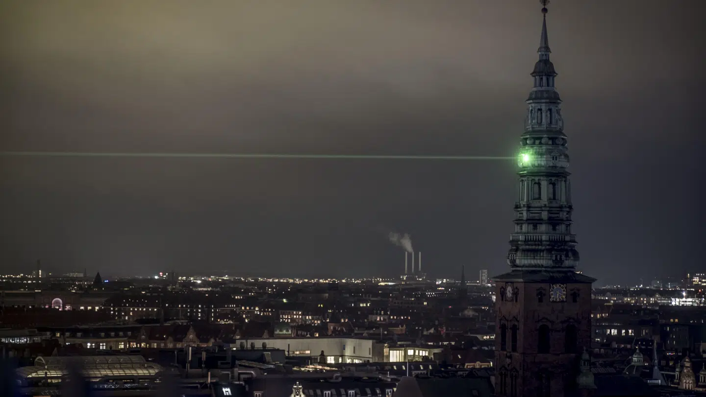 En grøn laserstråle lyser op i København.