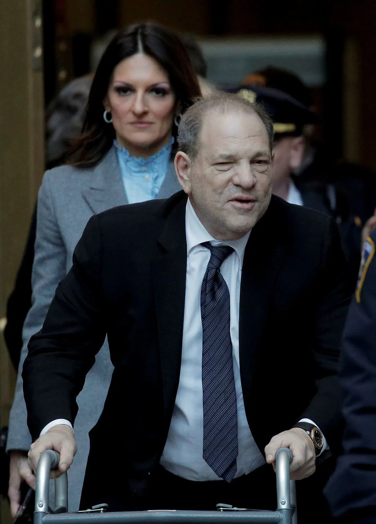 Harvey Weinstein med gangstativ. Bag Weinstein ses forsvarsadvokat Donna Rotunno.