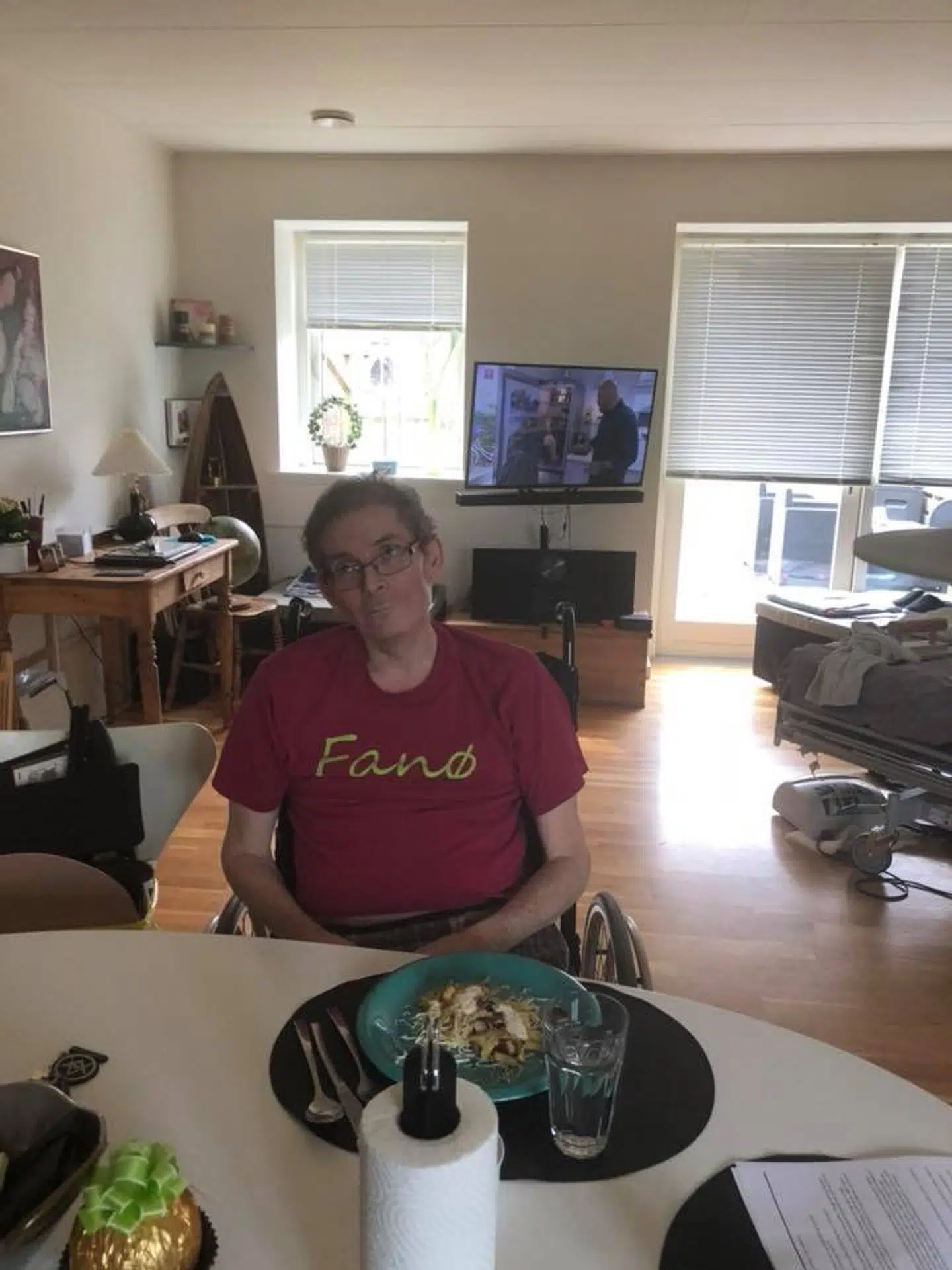 Henrik Vind i sin kørestol. I baggrunden kan man se hans sygeseng.