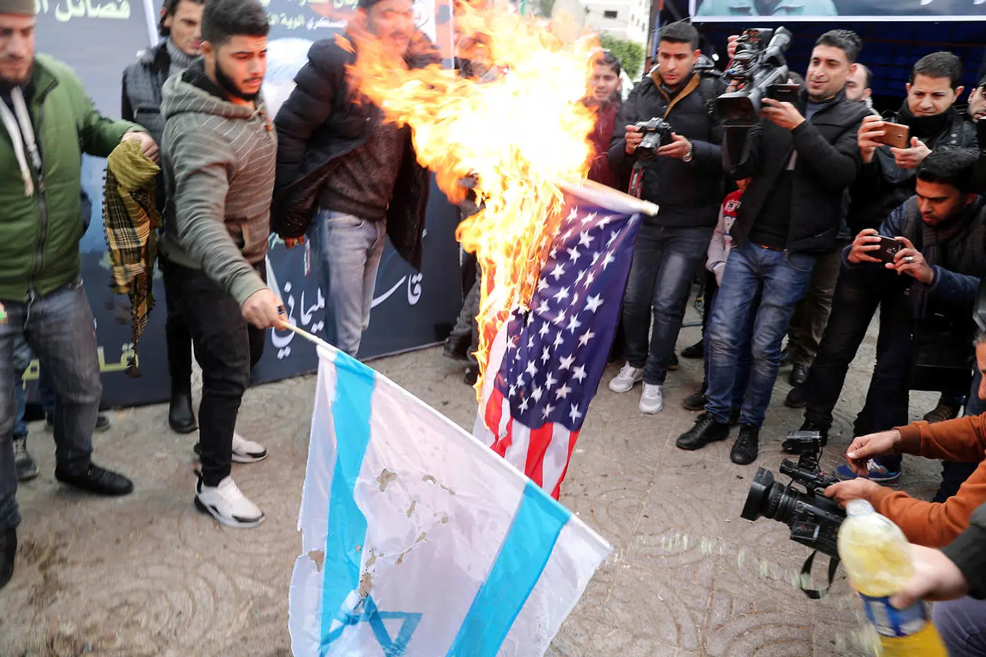 Palæstinensere brander det amerikanske og israelske flag af i Gaza.